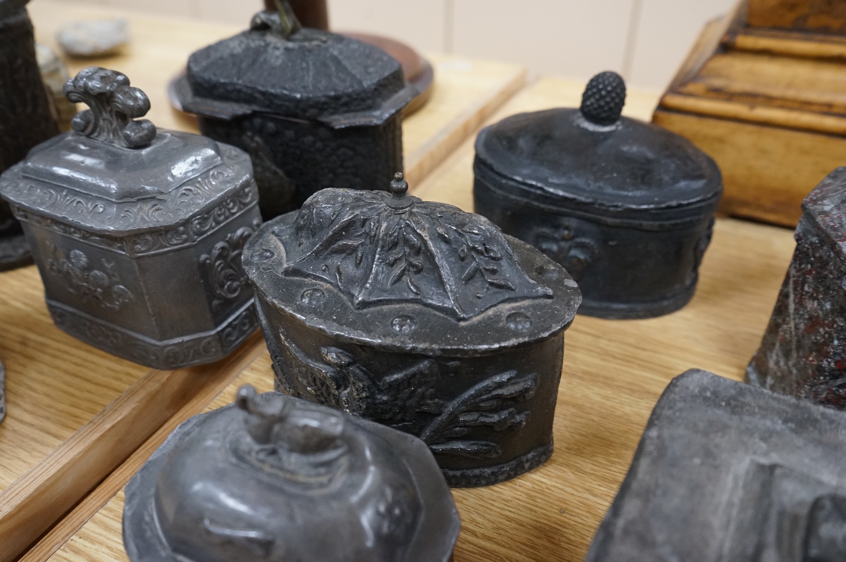 A collection of eleven early 19th century lead tobacco boxes to include an octagonal example with remains of red paint, largest 13cm wide
